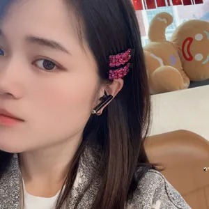 Détail en gros plan de la pince à cheveux latérale en strass rose scintillant pour un style doux.