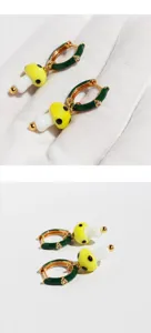 Chic green enamel huggie hoop earrings featuring cute yellow spotted glass mushroom pendants.