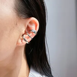 Close-up detail of multi-layer metal C-shaped ear cuffs, stylish non-pierced design.