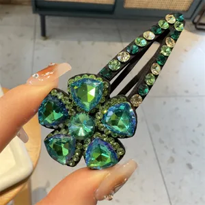 Gros plan sur la barrette fleur cristal vert, pince à cheveux strass scintillante pour frange.