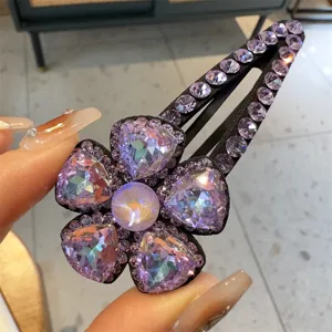 Vue détaillée de la pince à cheveux fleur en cristal coréen avec de magnifiques strass violets.