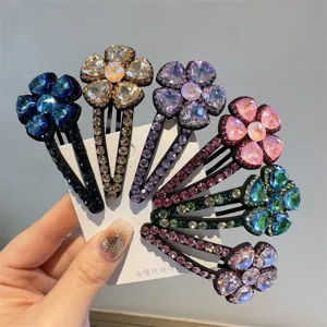 Gros plan de pinces a cheveux fleur en cristal colorees sur une carte, strass brillants.