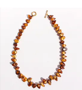 Détail de collier de perles baroques fait main avec perles marron irrégulières.