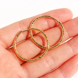 Orecchini a cerchio dorati martellati da donna, eleganti e minimalisti per ogni giorno.