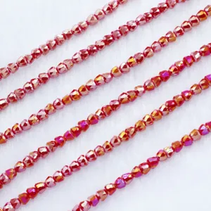 Gedetailleerde close-up van gefacetteerde rode kristalparels in strengen voor sieraden maken.