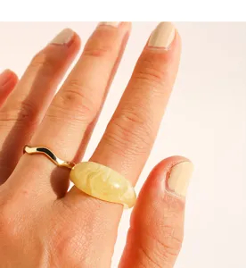 Gros plan détaillé de la bague empilable en résine ondulée dorée, bijou tendance.