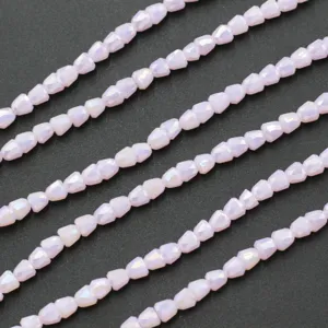 Gedetailleerde close-up van 4mm kristal belkraaltjes, lichtroze gefacetteerde kralen voor sieraden.
