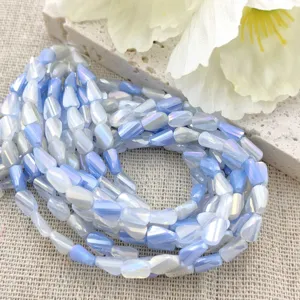 Close-up van blauw-witte verloop gedraaide geslepen kralen detail voor DIY handgemaakte sieraden.