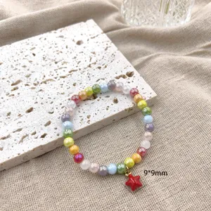 Gedetailleerde close-up van de kleurrijke kralenarmband met een schattige rode sterhanger.