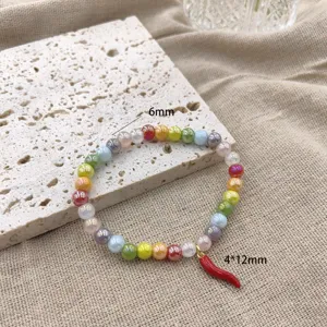 Detailopname van de kleurrijke kristalen kralen armband met schattige rode chili hanger.