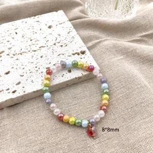 Prachtige dopamine kleurrijke kristalen kralen armband met rode hart hanger, detailweergave.