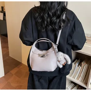 Minimalist leather bucket bag for women, stylish shoulder crossbody bag with furry bunny charm.
