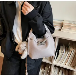 Detailed view of grey leather bucket handbag with toggle closure and cute bunny charm.