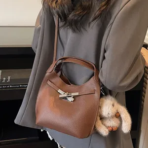 Stylish brown leather bucket bag for women, chic toggle closure shoulder and crossbody bag.