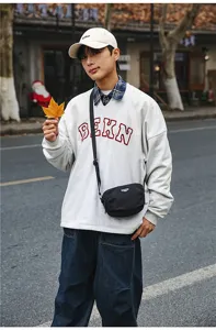 Detailed view of the casual outdoor crossbody bag worn by model on street, compact and stylish.