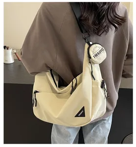 Casual large capacity canvas shoulder bag with crossbody strap and small round pouch.