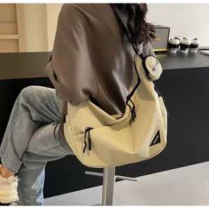 Detailed view of the large canvas crossbody bag showcasing stylish zipper and coin pouch design.