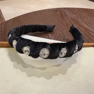 Close-up detail view of elegant black velvet rhinestone headband, sparkling crystal stones.