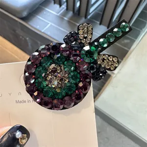 Vue rapprochée et très détaillée d'une belle pince à cheveux sucette en strass colorés.