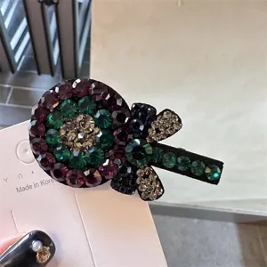 Vue rapprochée d'une jolie pince à cheveux en forme de sucette avec des strass tchèques colorés.