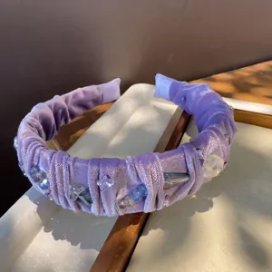 Detalle de diadema de terciopelo morado con cuentas de cristal, accesorio retro.