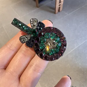 Gros plan détaillé du joli clip à cheveux en strass sucette, montrant des cristaux brillants.