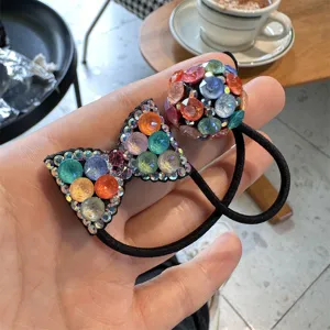 Close-up of a stylish colorful rhinestone bow and ball hair tie, perfect for daily fashion accessories.