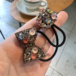 Close-up of sparkling rhinestone bow and ball hair ties, detailed crystal hair accessory view.