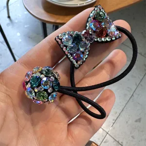 Close-up detail of the sparkling rhinestone bow and crystal ball hair tie accessory.