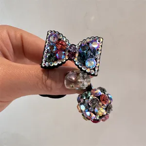 Close up of sparkling rhinestone bow and crystal ball hair tie, shining crystal details.