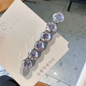 Gedetailleerde close-up van een sprankelende strass haarspeld met paarse kristalstenen.