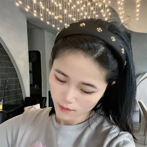 Black wide hair hoop with gold cross studs, elegant fashion hair accessory for women.