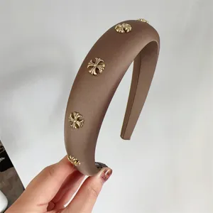 Brown wide headband detail shot featuring exquisite golden cross metal decorations for elegant style.