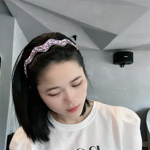 Detailaufnahme des wellenförmigen Strasshaarbandes mit funkelnden bunten Kristallen für Looks.