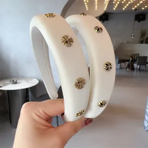 Wide padded headband in cream white with metallic cross decorations, elegant fashion hair accessory.