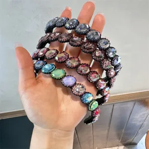 Primo piano dettagliato di cerchietti barocchi colorati in strass con cristalli lucidi.