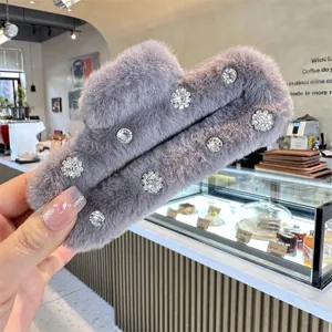 Grey fuzzy hair claw clip featuring sparkling rhinestone flower embellishments for elegant styling.