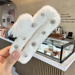 White fluffy hair claw clip with sparkling rhinestones, stylish plush winter hair accessory.