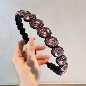Dettaglio in primo piano della fascia per capelli in cristallo viola con denti antiscivolo.