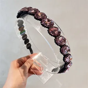 Vista dettagliata del cerchietto per capelli con strass viola scintillante stile barocco.