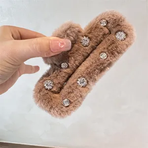Detail shot of brown plush rhinestone hair claw, showing fuzzy texture and crystal sparkle.