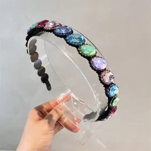 Dettaglio in primo piano di un cerchietto in cristallo barocco con strass colorati e denti.