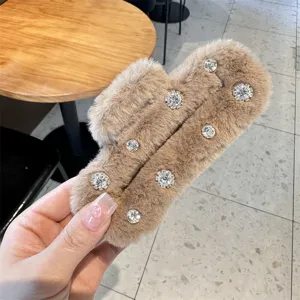 Fluffy brown plush hair claw clip detail featuring sparkling rhinestones for elegant styling.