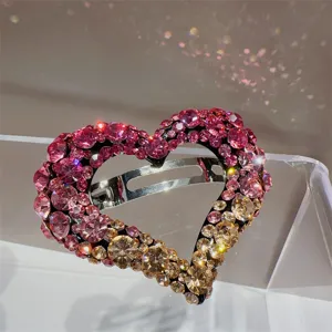 Gros plan de la pince a cheveux coeur en strass degrade, superbe accessoire chic et brillant.
