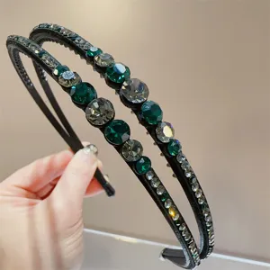 Gedetailleerde close-up van de dubbele strass-haarband, met sprankelende groene en grijze kristallen.