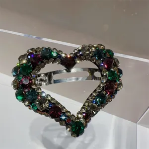 Détail de barrette à cheveux cœur en cristal étincelant, strass multicolores, accessoire élégant.