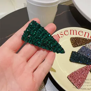 Détail de pince à cheveux triangulaire en strass vert, barrette étincelante élégante.