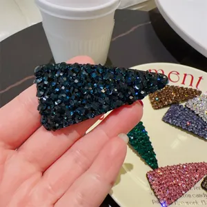 Vue détaillée de la pince à cheveux triangulaire en cristal bleu foncé, strass brillants.
