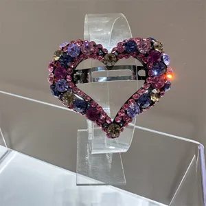 Gros plan de la pince à cheveux cœur en strass dégradé rose avec des cristaux brillants.
