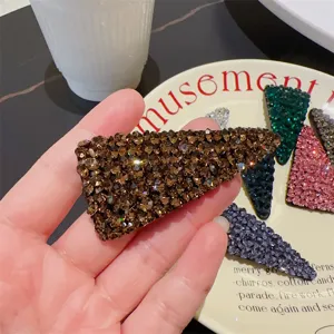 Détail de pince à cheveux triangulaire en strass brillant, élégant clip latéral chic.